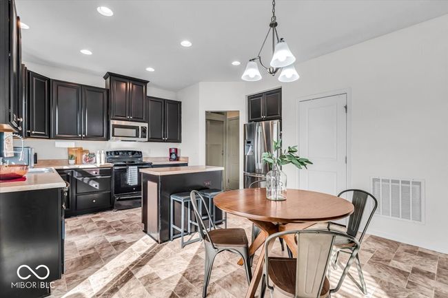 Kitchen with stainless steel appliances, plenty of counter and cabinet space, a large pantry and all the sunshine! | Image 12
