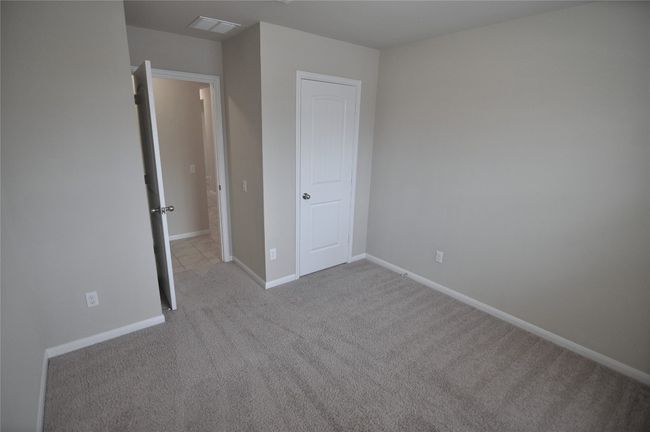 Unfurnished bedroom with visible vents, carpet, and baseboards | Image 4