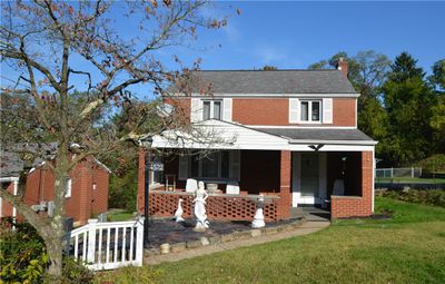 Front of home with large garden area and covered porch. | Image 1