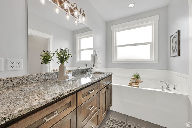 Bathroom with double vanity, a bath, tile patterned floors, and recessed lighting | Image 25