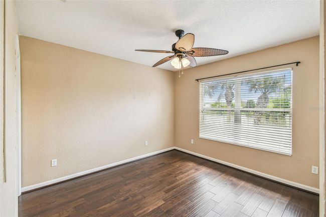The second upstairs bedroom offers an en-suite bathroom with a shower/tub combo and a serene view of the pond. | Image 19