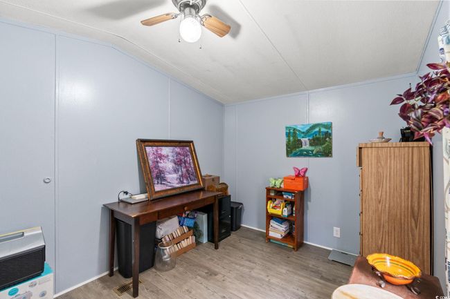 Home office featuring light wood-type flooring, lofted ceiling, and a ceiling fan | Image 18