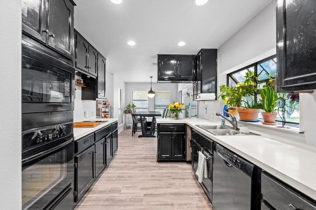 Kitchen featuring dark cabinets, a sink, recessed lighting, and black appliances | Image 11