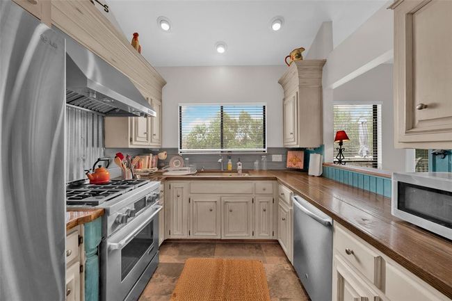 Kitchen with appliances with stainless steel finishes, healthy amount of natural light, wall chimney exhaust hood, decorative backsplash, and recessed lighting | Image 5