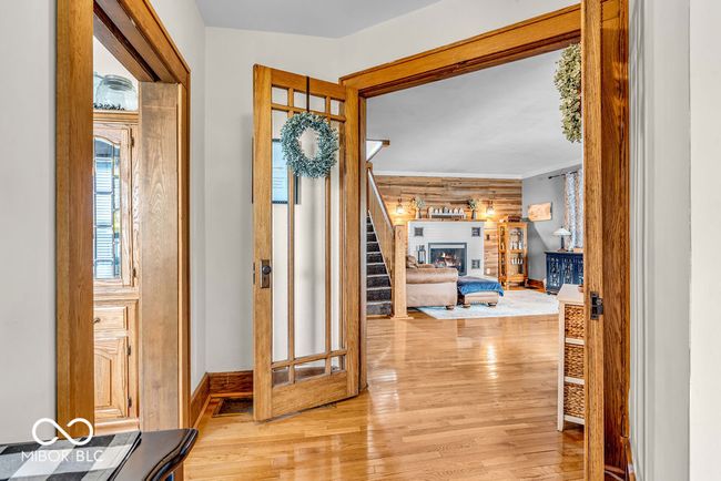 foyer entrance with wood finished floors, stairs, and a fireplace | Image 13