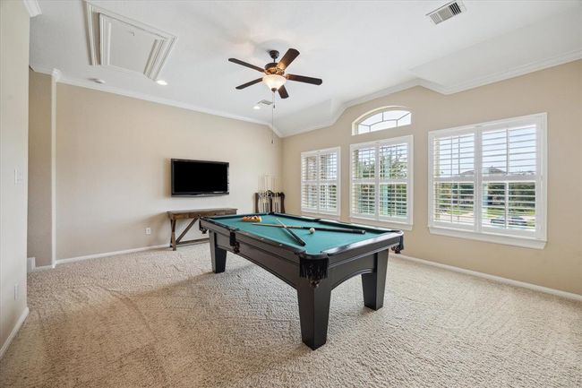 Oversized game room separate from all bedrooms with plantation shutters and great natural light | Image 30