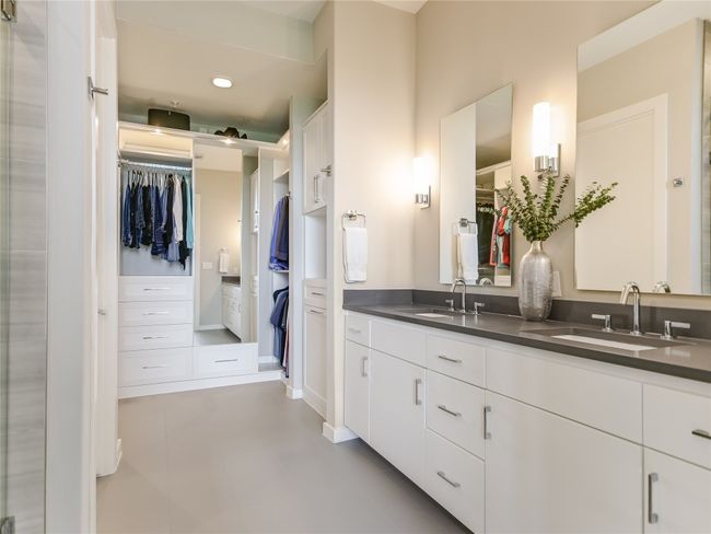 A major highlight of this unit is the remodeled clothing storage custom installed by California Closets. A wide and tall dual sink quartz vanity with white cabinets feature modern Grohe water faucets. | Image 14