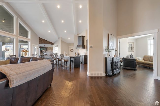 Living area with high vaulted ceiling, beamed ceiling, dark wood-type flooring, visible vents, and recessed lighting | Image 11