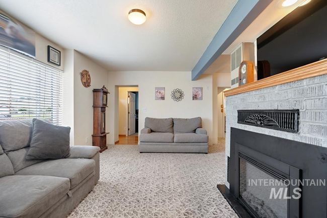 Carpeted living room featuring a fireplace | Image 10