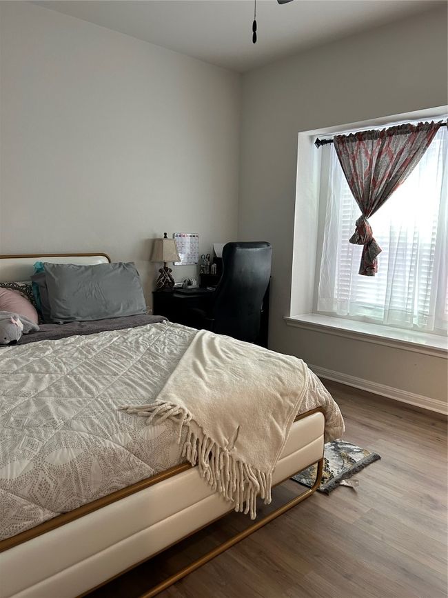 Bedroom featuring baseboards, wood finished floors, and multiple windows | Image 16