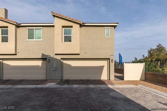 Townhome / multi-family property featuring a garage, driveway, stucco siding, and fence | Image 25