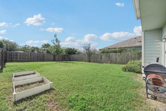 Fenced backyard featuring a vegetable garden | Image 21