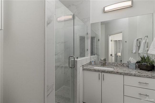 Full bath featuring a marble finish shower and vanity | Image 8
