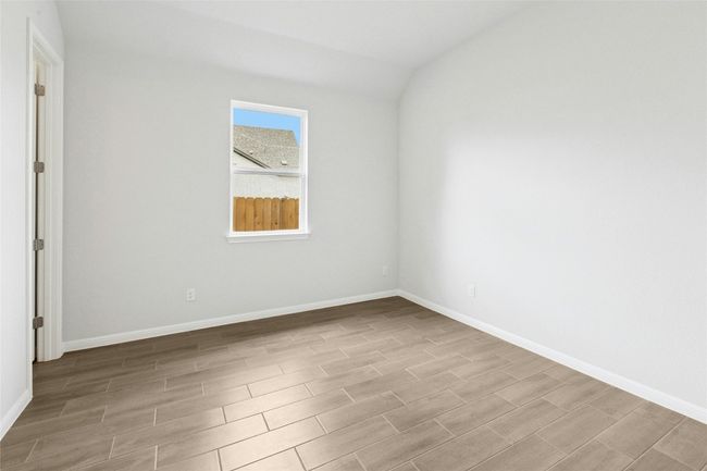 Empty room featuring wood finished floors, baseboards, and vaulted ceiling | Image 15
