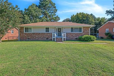 Ranch-style home with cooling unit and a front yard | Image 1