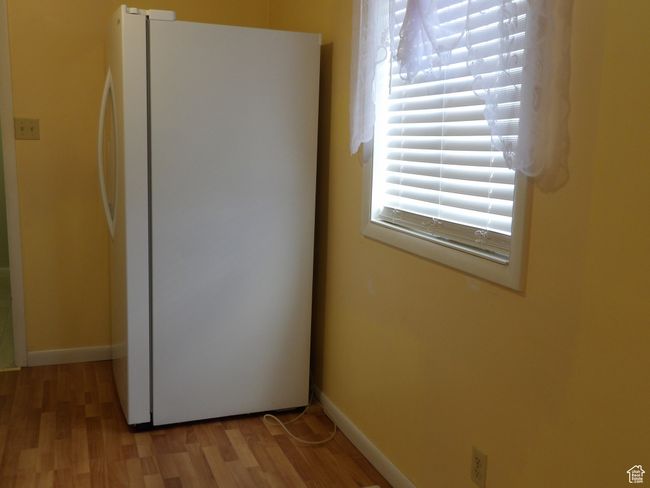 Details with white fridge and wood-type flooring | Image 21