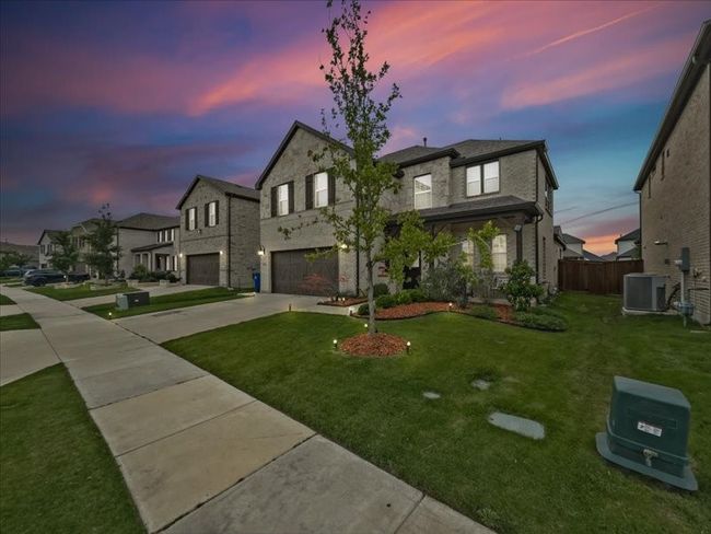 View of front of property with a garage, concrete driveway, central AC, and a residential view | Image 29