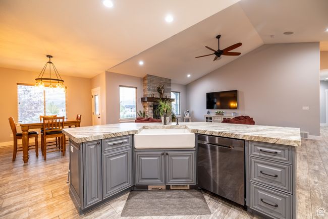 Kitchen with stainless steel dishwasher, gray cabinetry, light countertops, ceiling fan, and vaulted ceiling | Image 17