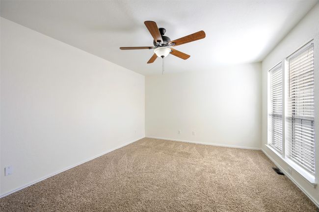 Empty room featuring baseboards, a ceiling fan, visible vents, and light carpet | Image 16