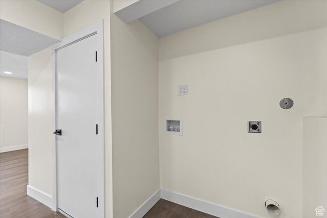 Washroom with washer hookup, dark wood finished floors, hookup for an electric dryer, laundry area, and baseboards | Image 19