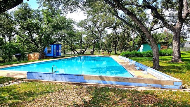 View of swimming pool featuring a lawn, an outbuilding, fence, a fenced in pool, and a shed | Image 22