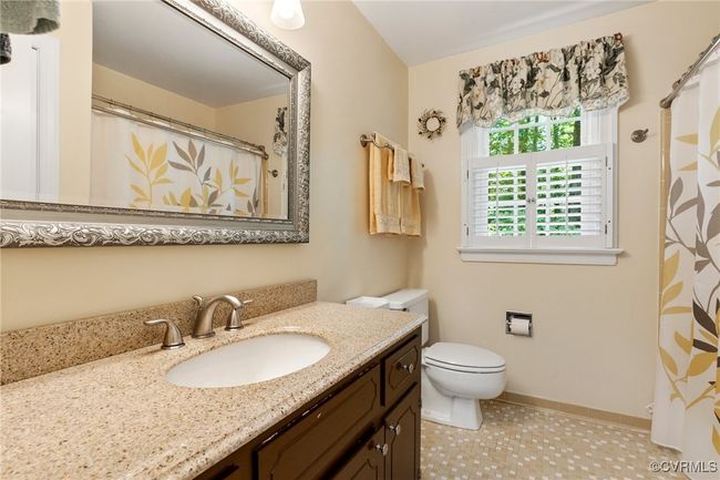 Bathroom featuring vanity and curtained shower | Image 32