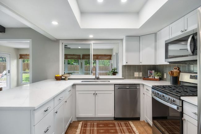 Kitchen looks to sunroom | Image 11