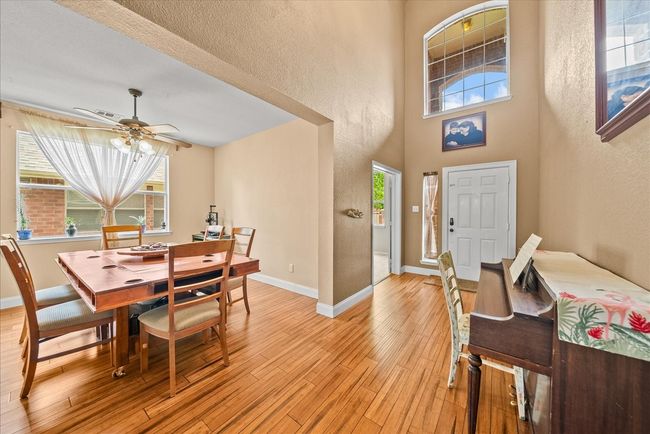 Dining area with light wood-style flooring, a textured wall, ceiling fan, and baseboards | Image 5