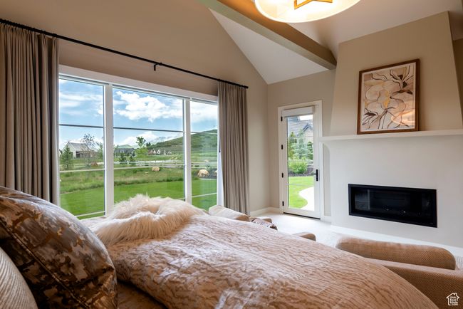 Bedroom with access to outside, a glass covered fireplace, and high vaulted ceiling | Image 27