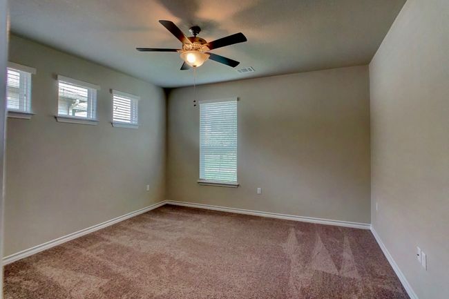 Empty room featuring carpet, baseboards, visible vents, and a ceiling fan | Image 11