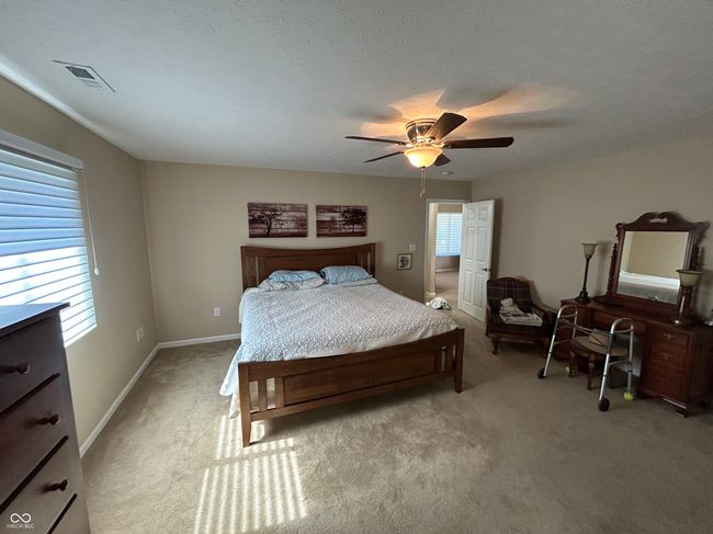 bedroom featuring baseboards, visible vents, light colored carpet, and ceiling fan | Image 13