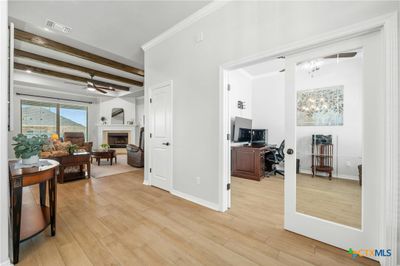 As you enter the home, you're immediately greeted with custom details, like a beamed tray ceiling in the living room. | Image 3