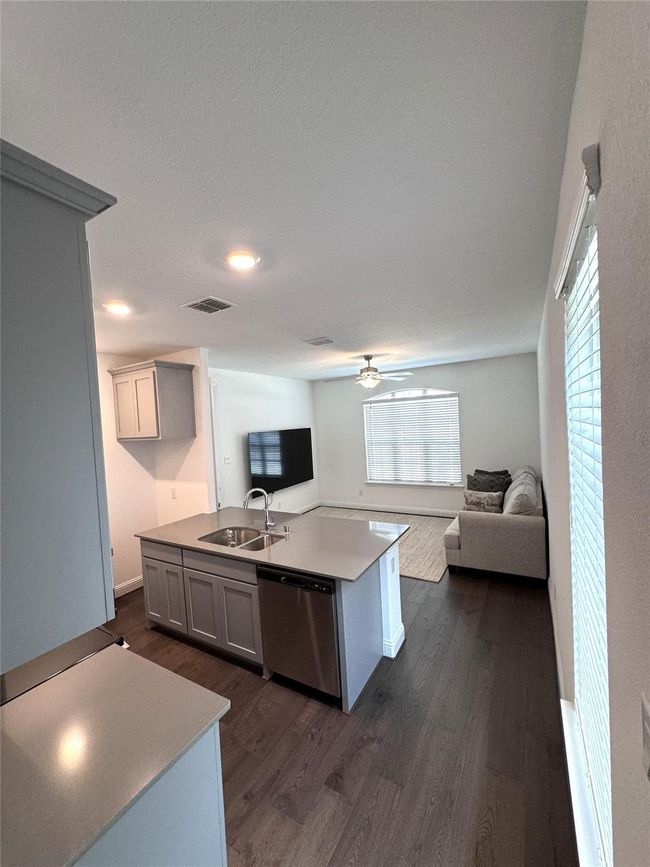 Kitchen with dishwasher, open floor plan, dark wood-type flooring, and a ceiling fan | Image 12