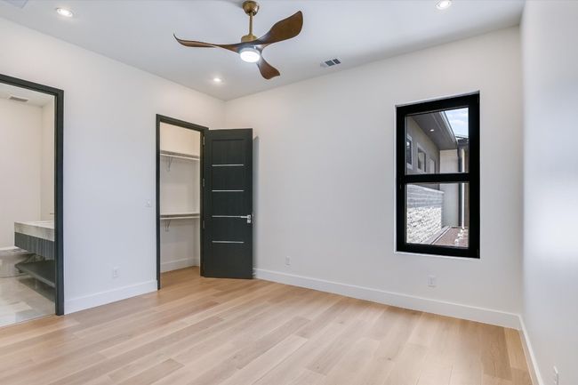 Guest bedroom with light wood flooring, a spacious closet, recessed lighting, ensuite bathroom, and a closet | Image 31