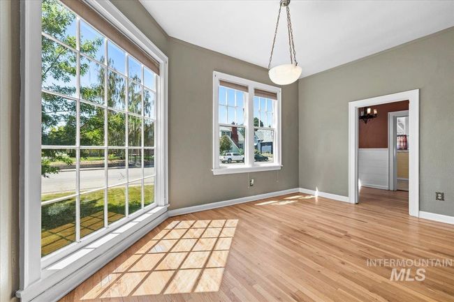 Unfurnished dining area with light wood finished floors, a chandelier, and crown molding | Image 10