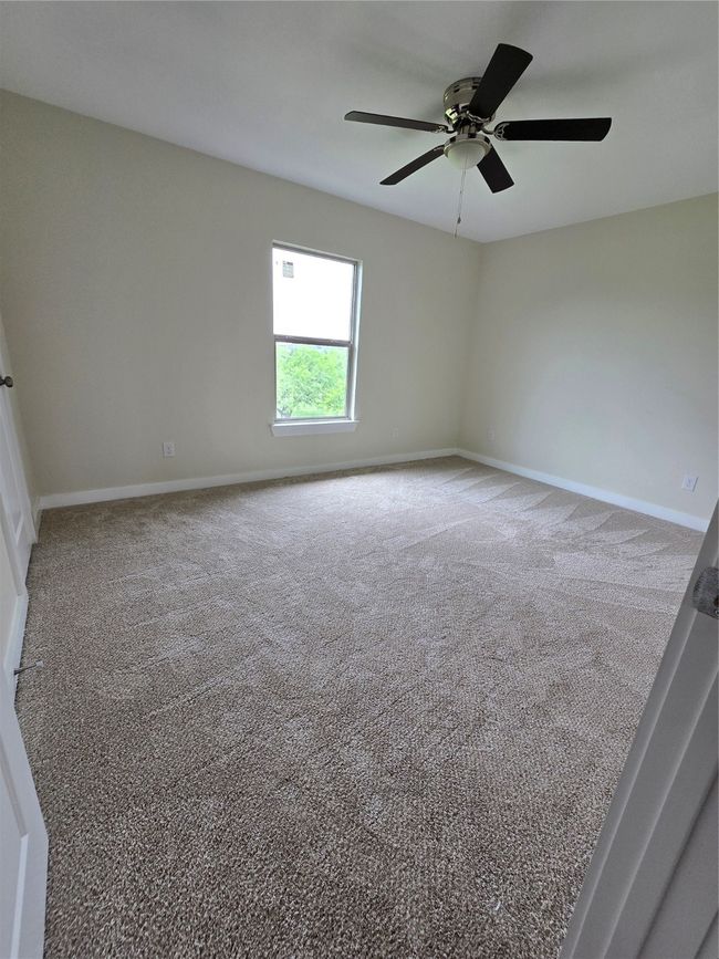 Carpeted spare room featuring a ceiling fan and baseboards | Image 29
