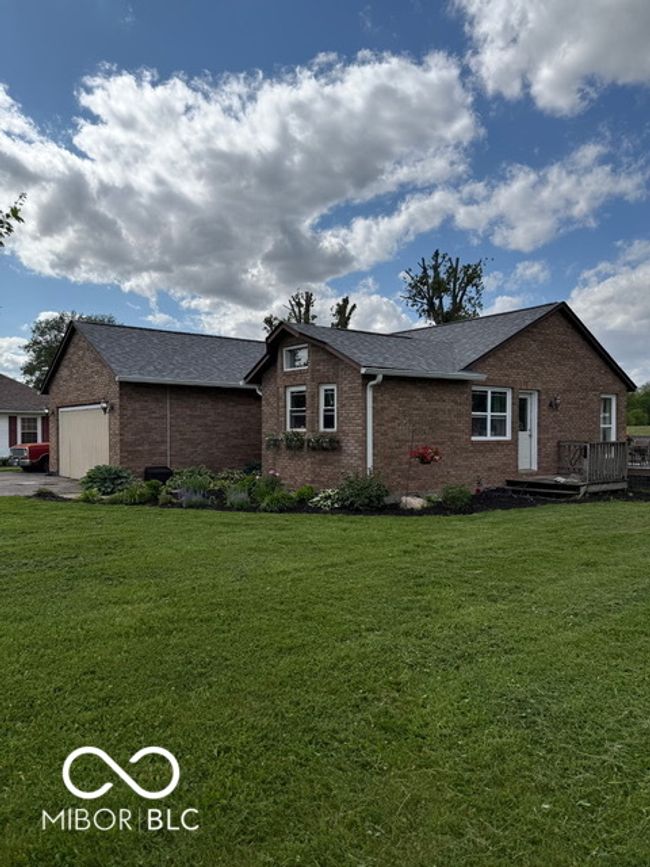 view of front facade featuring brick siding, a front yard, and a shingled roof | Image 5