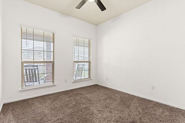 Unfurnished room with dark colored carpet and a ceiling fan | Image 18