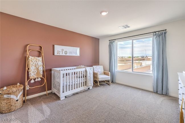 Photo is representational only; actual home finishes may vary. Carpeted bedroom featuring baseboards and a crib | Image 32