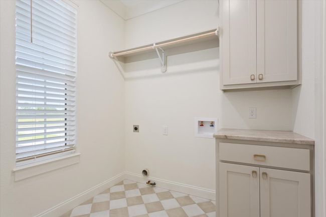 Laundry room featuring washer hookup, light floors, hookup for an electric dryer, cabinet space, and gas dryer hookup | Image 33
