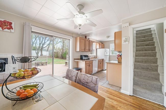 Dining space with a toaster, light wood-type flooring, a ceiling fan, and stairs | Image 11