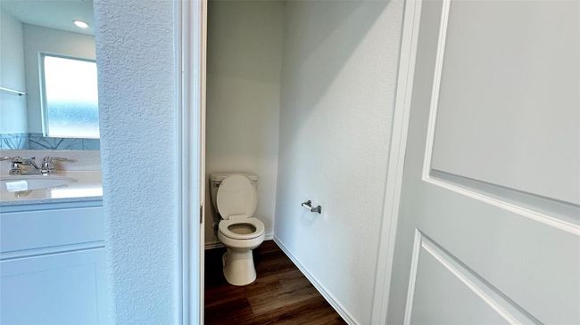 Bathroom with toilet, baseboards, wood finished floors, and vanity | Image 22