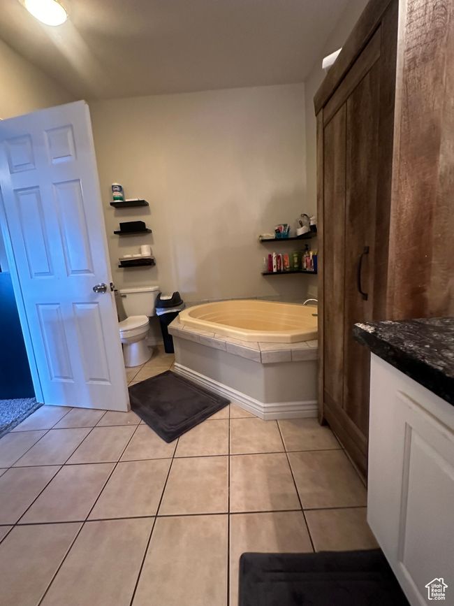 Full bath featuring toilet, a garden tub, tile patterned flooring, and vanity | Image 16