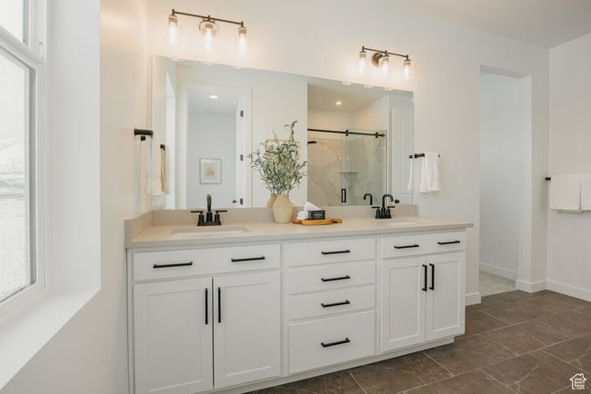 Full bath featuring double vanity, a shower stall, healthy amount of natural light, and marble finish floors | Image 29