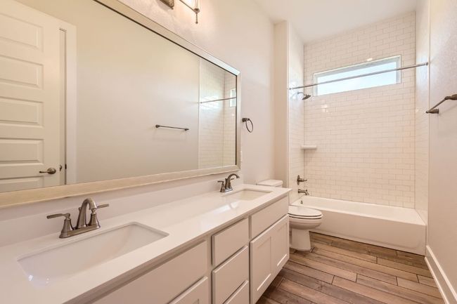Bathroom featuring wood finished floors, a sink, double vanity, and toilet | Image 23