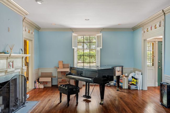 Sitting room with wainscoting, a fireplace, ornamental molding, wood finished floors, and a decorative wall | Image 10