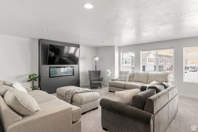 Living room featuring a large fireplace, baseboards, light carpet, recessed lighting, and a textured ceiling | Image 18