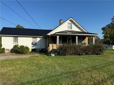 View of front of home with central air condition unit and a front yard | Image 1