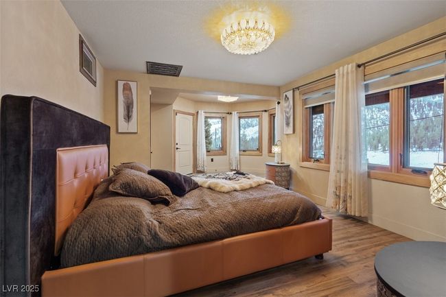 Bedroom featuring an inviting chandelier, visible vents, baseboards, and wood finished floors | Image 45