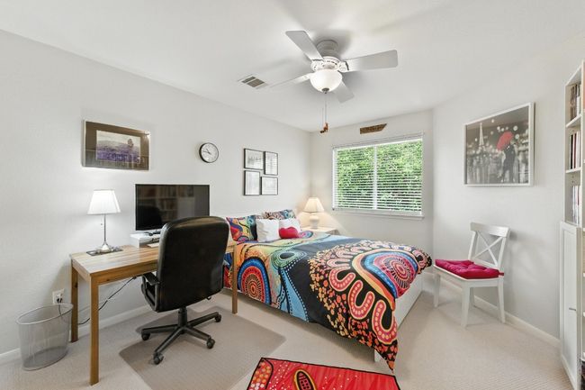 Bedroom featuring carpet flooring, a ceiling fan, and an office area | Image 24